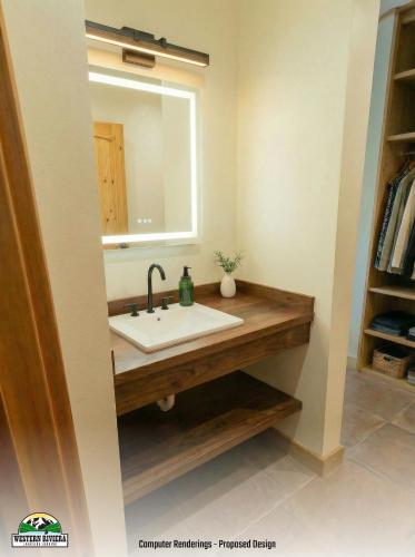 a bathroom with a sink and a mirror at Western Riviera Lakeside Lodging in Grand Lake