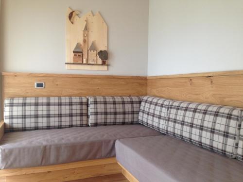 a couch in a room with two plaid at Hotel Ambassador in Levico Terme