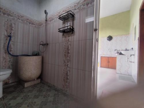 a bathroom with a shower and a toilet and a sink at mas dylan homestay in Probolinggo