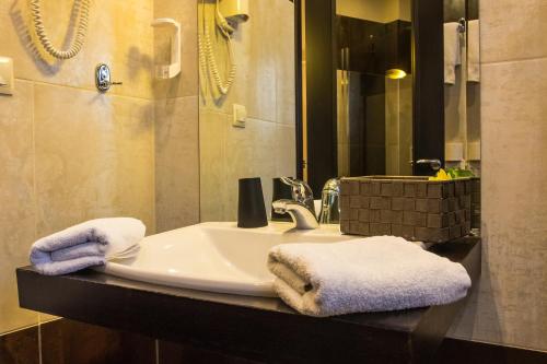 y baño con lavabo y toallas. en Giotis Boutique Hotel, en Ioannina