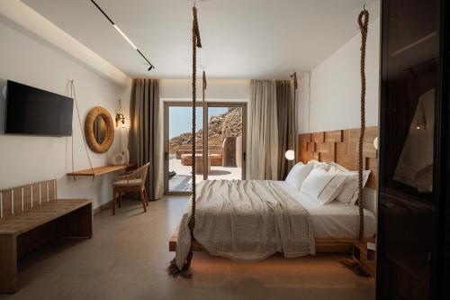 a bedroom with a swinging bed and a balcony at GkF Luxury Villas in Naxos Chora