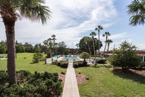 a pathway through a park with palm trees at Motel 6-Spring Hill, FL - Weeki Wachee in Weeki Wachee