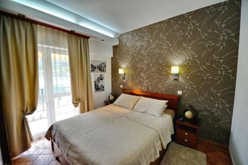 a bedroom with a bed and a large window at BMB Apartments Kotor in Kotor