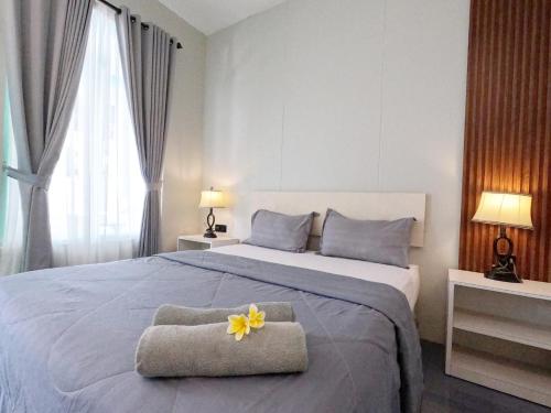 a bedroom with a large bed with a yellow flower on it at Villa PhyPhy 3 in Gili Trawangan