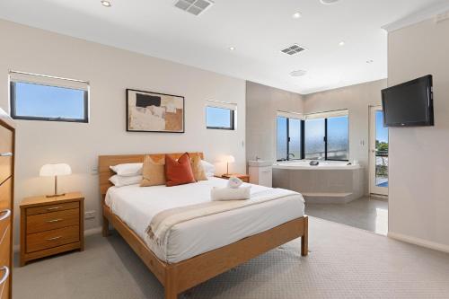 a bedroom with a bed and a bathroom with a tub at Walk to the Mandurah Foreshore & Marina in Mandurah