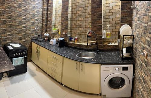 a kitchen with a sink and a washing machine at The House Of Love in Luxor
