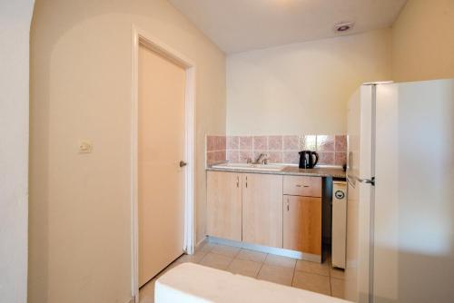 a kitchen with a refrigerator and a sink at Gardenos Hotel in Vitalades