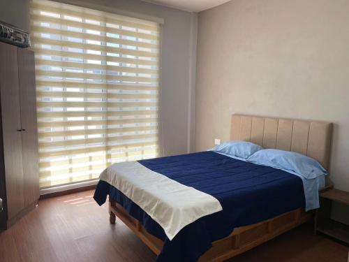 a bedroom with a bed and a large window at Moderno departamento en Tula in Tula de Allende