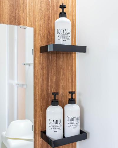 two bottles of shampoo and soap on a shelf in a bathroom at 巡り宿香西本町-最大10名 in Takamatsu