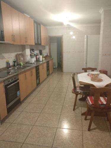 a large kitchen with a table and a table and chairs at apartment with 5 bedrooms in Bragança