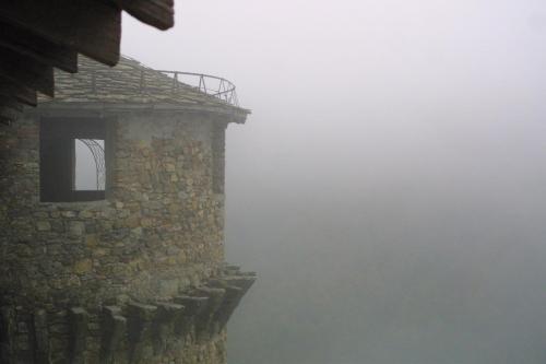 a window on the side of a building in the fog at Castello Di Compiano Hotel Relais Museum in Compiano