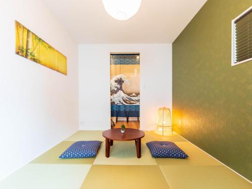 a room with a table and a painting on the wall at 巡り宿香西本町-最大10名 in Takamatsu