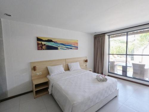 a bedroom with a bed and a large window at Villa PhyPhy in Gili Trawangan