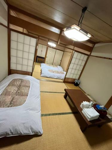 a room with a bed and a table and mirrors at 苗場ウッドインだいまる in Yuzawa