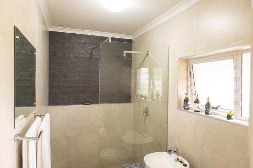 a bathroom with a glass shower and a sink at Harmony House in Ladysmith