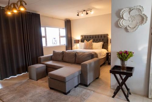 a bedroom with a bed and a couch and a chair at Harmony House in Ladysmith