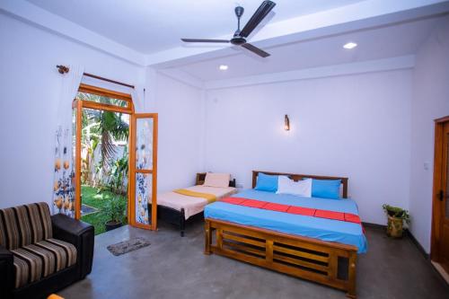 a bedroom with a bed and a couch at Seyoo Villa in Ahangama