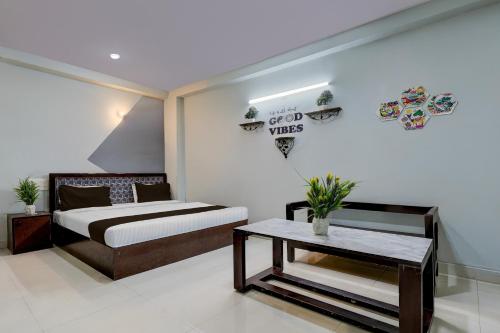 a bedroom with a bed and a table in it at Super Hotel O Dadri Main Road Greater Noida in Greater Noida