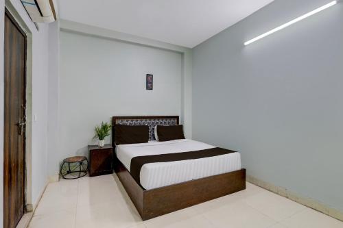 a bedroom with a bed in a white room at Super Hotel O Dadri Main Road Greater Noida in Greater Noida