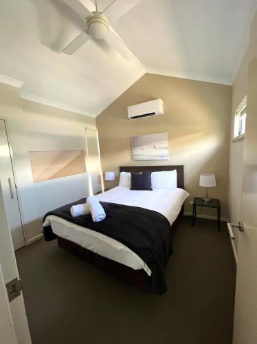 a bedroom with a large bed with a ceiling fan at 2 bed self-contained Beach Shack in Preston Beach