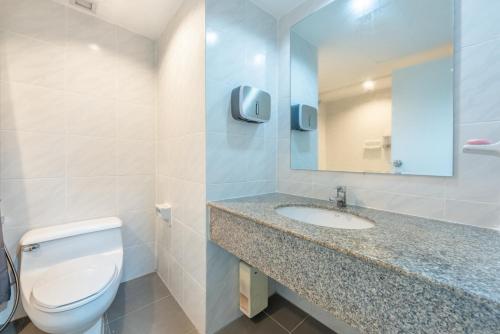 a bathroom with a toilet and a sink and a mirror at Neom Town Residence in Bangkok