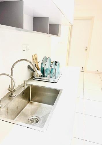 a kitchen sink with dishes on a counter at Angelic stay in Hulhumale