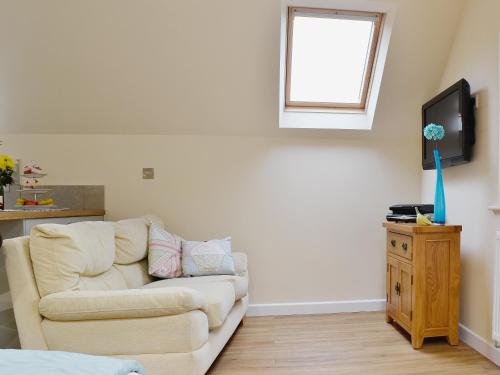 a living room with a couch and a television at Magpie's Rest in Horrabridge