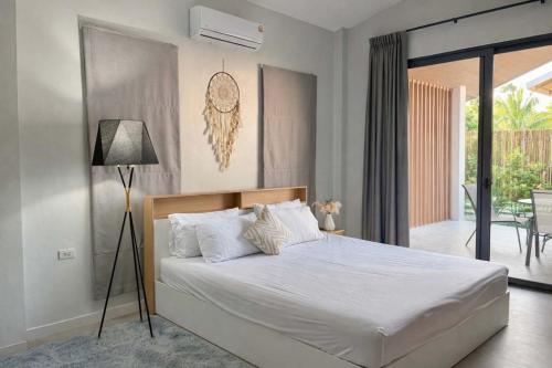 a bedroom with a large bed and a balcony at Cocolane Villa 4 in Hinkong