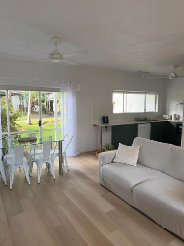 a living room with a couch and a table at Tropical Palms Port Douglas in Port Douglas