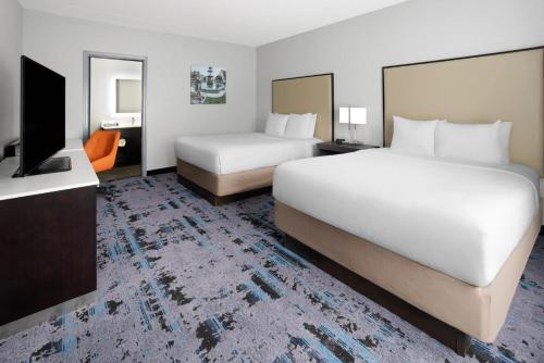 a hotel room with two beds and a flat screen tv at Hawthorn Extended Stay by Wyndham Chambersburg in Chambersburg
