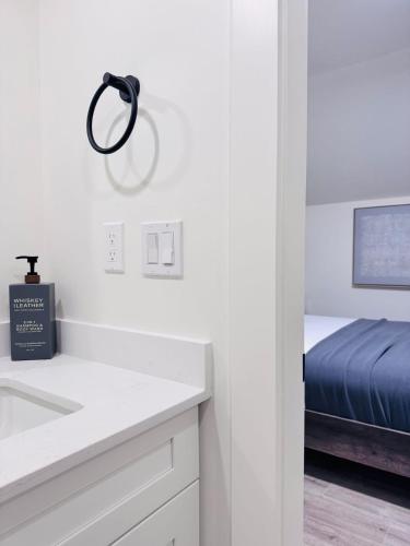 a white kitchen with a sink and a bed at Modern Queen Room Ensuite Bathroom Vancouver West in Vancouver