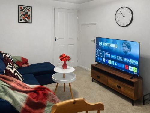 a living room with a blue couch and a tv at Richborough House in Saint Peters