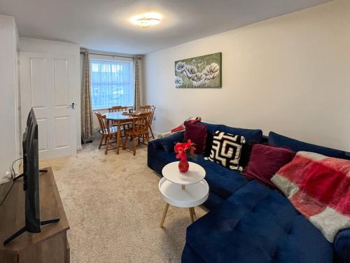 a living room with a blue couch and a table at Richborough House in Saint Peters
