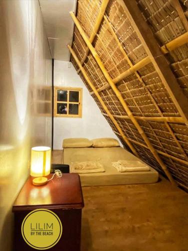 a room with two beds and a table with a lamp at Duplex B- Seaside Haven Transient Inn at Caba, La Union in Caba
