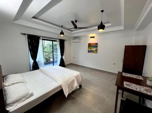 a bedroom with a large bed and a window at Morden AC 1bhk apartment near Cavelossim beach - Amor in Cavelossim