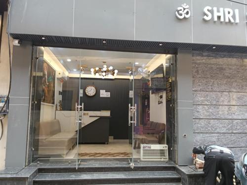 a store front with a glass door with a clock at Gokul Dham in Haridwār