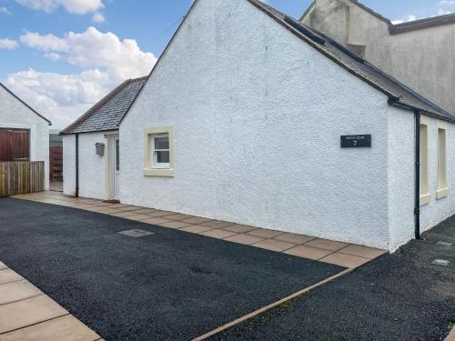 a white building with a sign on the side of it at Taigh-Beag - Uk50660 in Wigtown