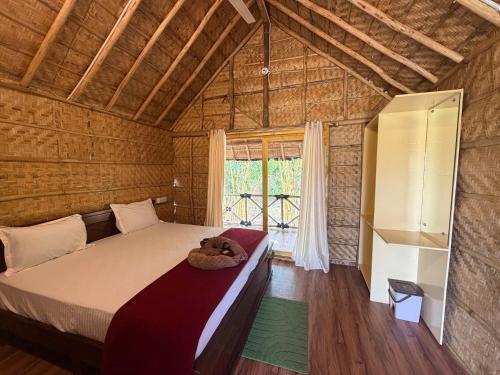 a bedroom with a bed with a teddy bear on it at Monkey Paradise Hampi in Hampi