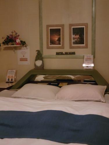 a bed with two pillows in a room at ホテルNO name in Tōgane
