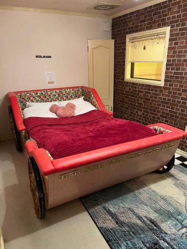 a teddy bear laying on a bed in a room at ホテルNO name in Tōgane