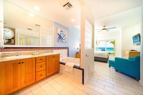 a bathroom with a tub and a sink and a bath tub at The Reef Beach Resort, East End, Grand Cayman in Sand Bluff