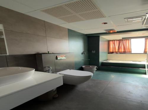 a bathroom with a white toilet and a sink at WINTEL WILD in Vālpārai