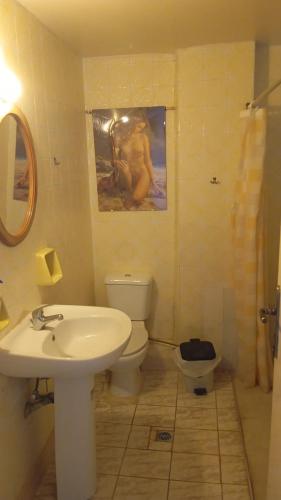 a bathroom with a sink toilet and a painting on the wall at HELLAS PALACE ROOMS balcony in Sparta