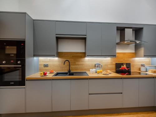 a kitchen with white cabinets and a sink at The Aran - Uk51067 in Frongoch