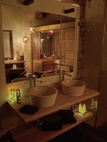 a bathroom with three sinks and a large mirror at Faschingalm Loft in Lienz