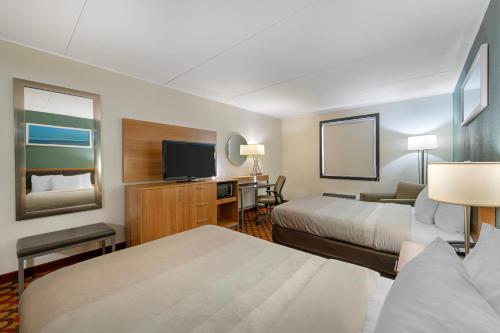 a hotel room with two beds and a flat screen tv at Quality Inn Enola - Harrisburg in Harrisburg
