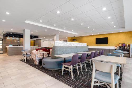 a dining area with tables and chairs in a restaurant at Home2 Suites By Hilton New Braunfels in New Braunfels