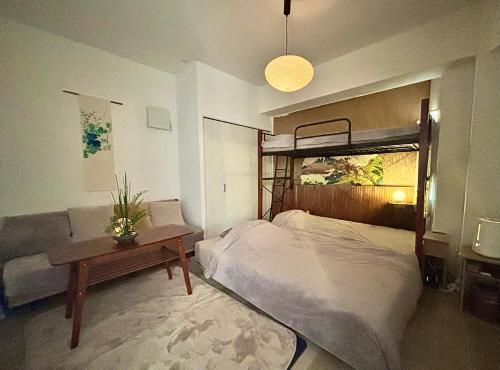 a bedroom with a bed and a table and a couch at Momotarou Stay in Yokohama