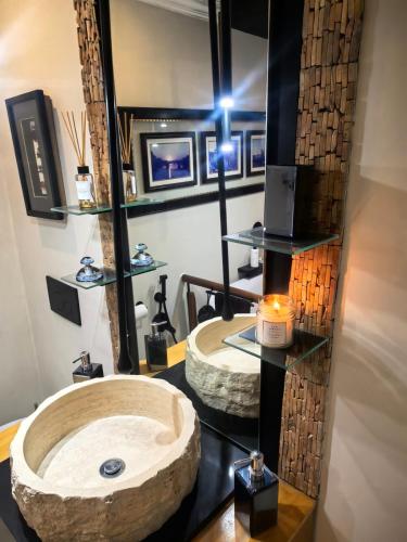 a bathroom with a large stone sink and a mirror at Boutique Inn - Quintessence in Gordonʼs Bay