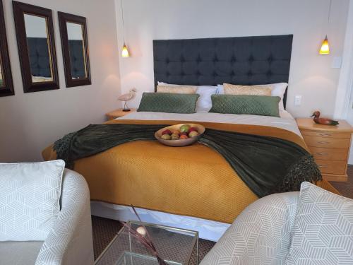 a bedroom with a bed with a bowl of fruit on it at Boutique Inn - Quintessence in Gordonʼs Bay